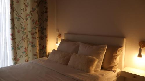 a bedroom with a bed with white sheets and pillows at Estadia dos Sonhos in Sequeiros