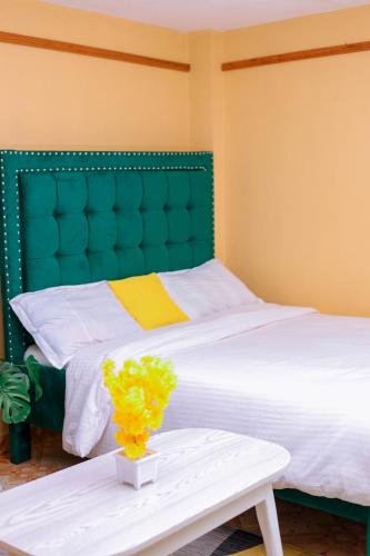 a bed with a vase of flowers on a table at Monett Bay in Wajir