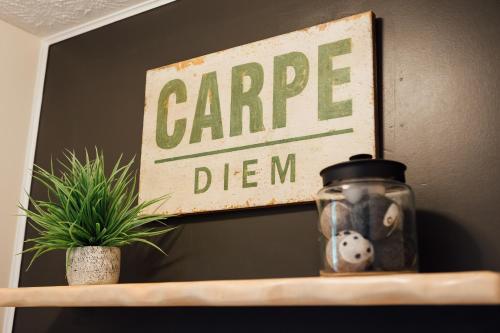 a sign hanging on a wall above a shelf with a plant at 6 min from Downtown Dahlonega, Wine Country, Game Room in Dahlonega