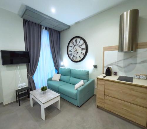a living room with a couch and a clock on the wall at New studio next to Ruzafa in Alcácer