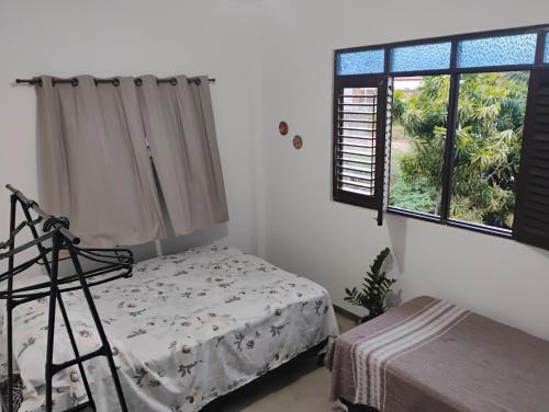 a bedroom with a bed and a window at Hospedaria Su in Parnamirim