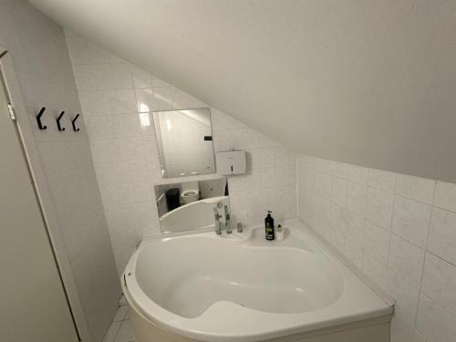 a white bathroom with a sink and a mirror at B&M Studio self-check in in Vilnius