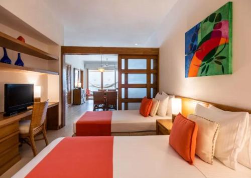 a hotel room with two beds and a television at Hotel Irotama del Sol in Santa Marta
