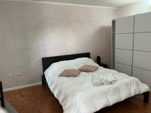 a bedroom with a white bed with two pillows at S'Intrada in Thiesi