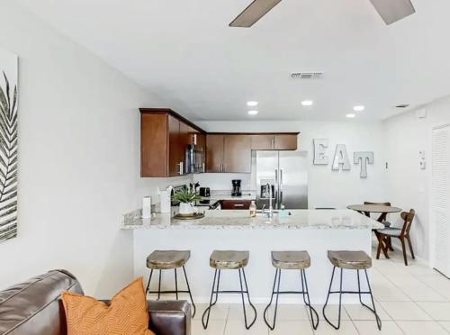 a kitchen with a large white counter and stools at Family & Pet Friendly-Waterfront-Sleeps 4 in Apollo Beach