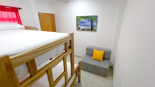 a bedroom with a bunk bed and a chair at Habitación Manglares 103 in Coveñas