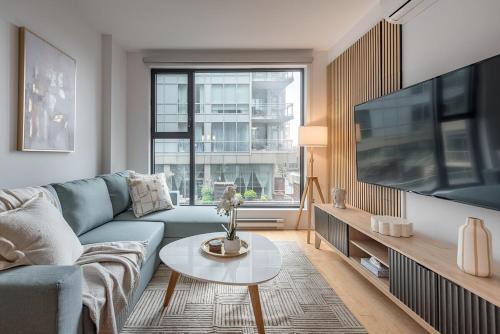 a living room with a blue couch and a tv at Old Port Upscale - Free Indoor Parking in Montréal