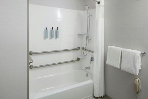 a white bathroom with a tub and a shower at Courtyard by Marriott Waldorf in Waldorf