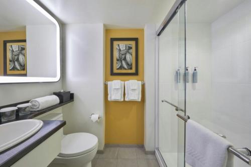 a bathroom with a toilet and a sink and a shower at Courtyard by Marriott Waikiki Beach in Honolulu