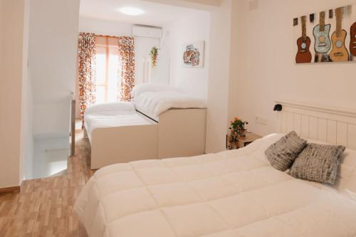 a bedroom with two beds and a couch at Casa Las niñas in La Algaba