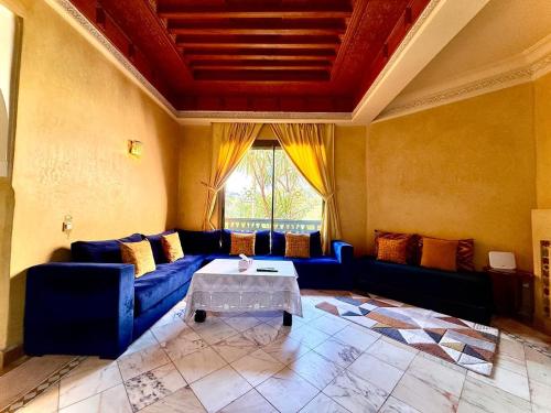 マラケシュにあるLes Jardins de la palmeraieの青いソファとテーブルのあるリビングルーム