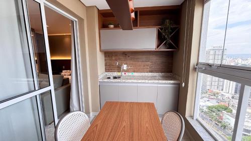 a dining room with a table and chairs and a window at #2905# Flat incrível– Lounge 22 | Setor Oeste in Goiânia