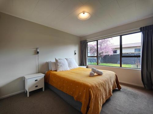 a bedroom with a bed and a large window at Luxmore Lookout in Te Anau