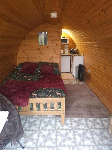 a bedroom with a bed in a wooden room at Blackditch hideaway cabin in Kildare