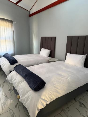 two beds sitting next to each other in a room at Ronda Guesthouse in Matsapha