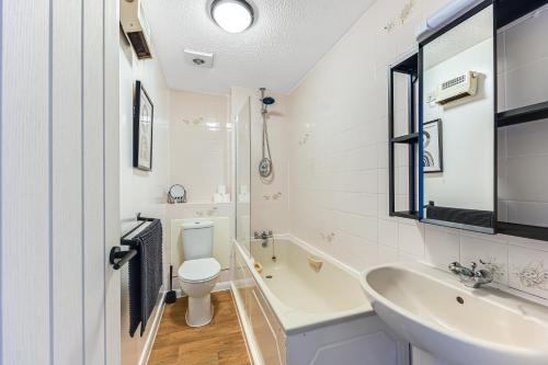 a white bathroom with a sink and a toilet at Cosy Sleeps 5 Bedford Stay Superfast WiFi in Bedford