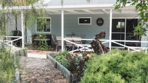 a house with a porch with a table and chairs at Boat Ramp Shack in Coffin Bay