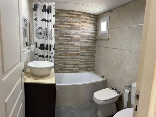 a bathroom with a tub and a toilet and a sink at Latitud 28 in Mar Azul
