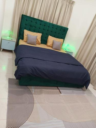 a bedroom with a large bed with a green headboard at Luxury 2-Bedroom Family Apartment on Buhaira Corniche in Sharjah
