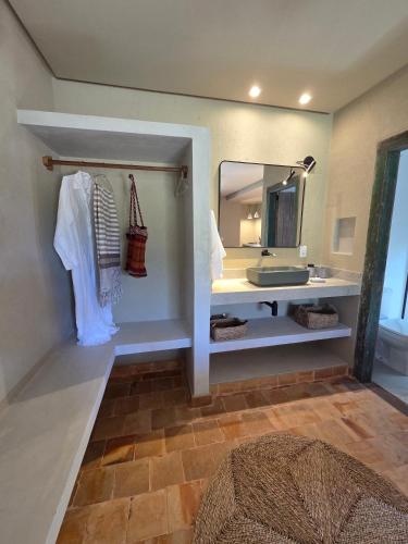 a bathroom with a sink and a mirror at Casa de Hóspedes da Lili & André in Caraíva