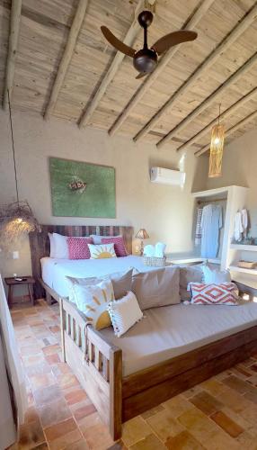 a living room with a couch and two beds at Casa de Hóspedes da Lili & André in Caraíva