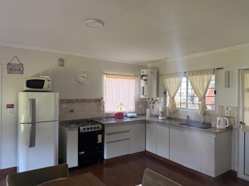 a kitchen with white cabinets and a white refrigerator at paraíso la Caleta in Mar de Cobo