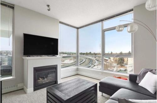 a living room with a fireplace and a tv at The Spruce Modern 2BR Condo with Pool & Parking in Calgary