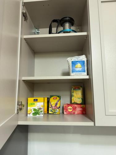 a cupboard with some food items in it at Apartament Brazdă in Craiova