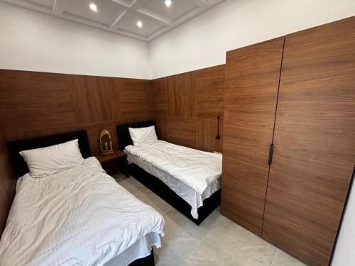 a bedroom with two beds and wooden cabinets at Dom nad jeziorem Winna Górka 