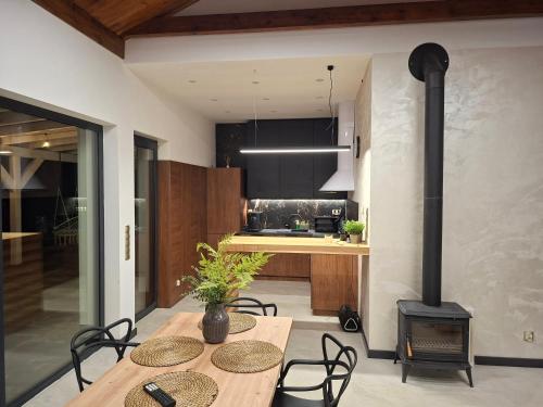 a kitchen with a table and a wood stove at Dom nad jeziorem Winna Górka 