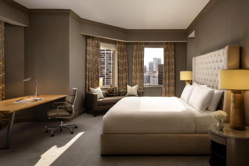 a hotel room with a bed and a desk and a window at Fairmont Chicago Millennium Park in Chicago