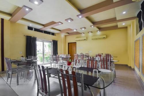 a restaurant with tables and chairs in a room at Hotel O Ritz Rivera in Kolkata