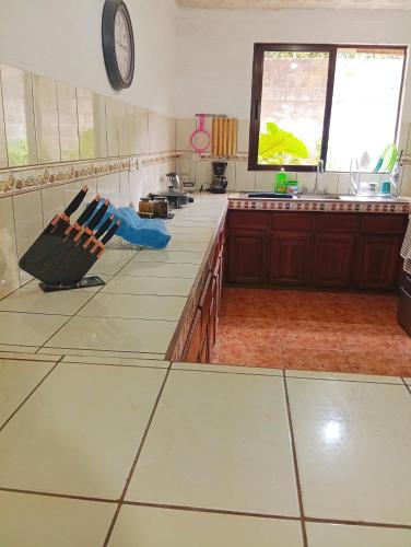a kitchen with white counter tops and a clock on the wall at Casa de descanso in Alajuela City