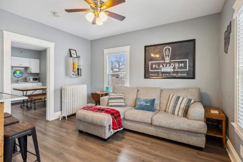 a living room with a couch and a kitchen at BrewLoft Cleveland - Near Rock Hall & Downtown in Lakewood