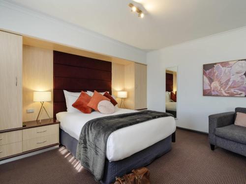 オルベリーにあるMercure Alburyの大きなベッドと椅子のあるホテルの部屋
