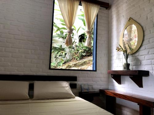 a bedroom with a bed and a mirror on the wall at Paraiso de Angra in Angra dos Reis