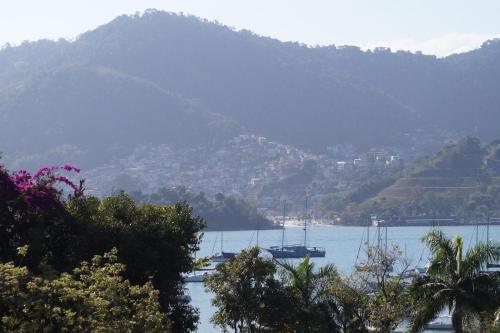 a group of boats in a body of water with mountains at Paraiso de Angra in Angra dos Reis