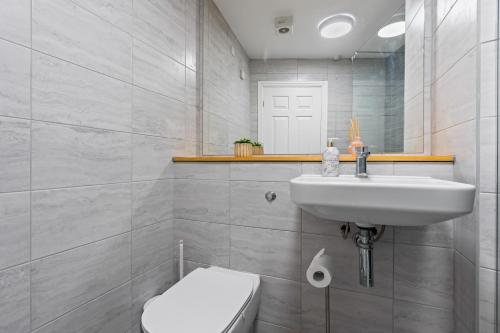 Un baño con lavabo, inodoro y espejo. en Leeds Central Hub - Free Parking - Sleeps 5, en Leeds
