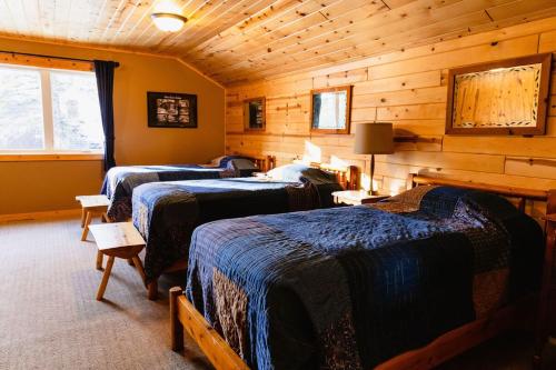 a bedroom with three beds in a log cabin at Spruces at Pine Cone Lodge- Big Sand Lake in Park Rapids