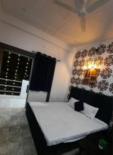 een slaapkamer met een bed in een kamer met een raam bij The Moksha Residency By MOM'S in Prayagraj