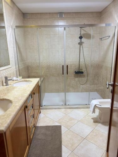 a bathroom with a shower and a sink at Mãos n'Areia in Ferrel