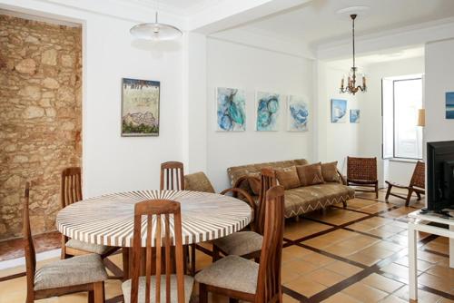 a living room with a table and a couch at Casa do Poço in Faro