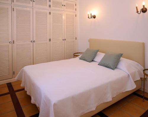 a bedroom with a large white bed with two pillows at Casa do Poço in Faro