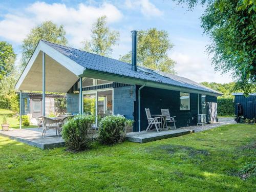 a small blue house with a table and chairs at Secluded Haven in Kelstrup - By Traum Ferienwohnungen in Kelstrup Strand