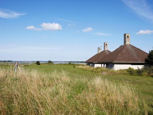 a building in the middle of a field with tall grass at 3 room in holiday park in Karrebæksminde in Karrebæksminde