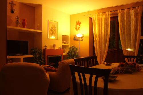 sala de estar con mesa, sillas y TV en Affittacamere La Vigna, en Serramezzana
