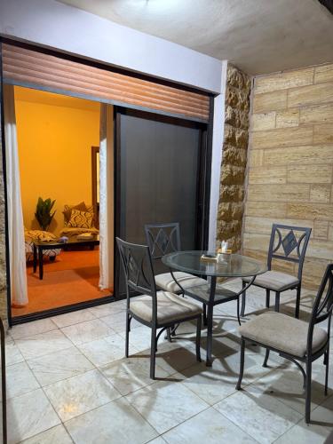 a dining room with a glass table and chairs at Abdallah Wa'el Adham in Aqaba