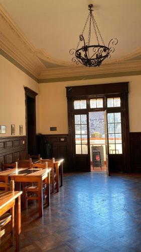 a dining room with wooden tables and a chandelier at Mitre778 in Rosario
