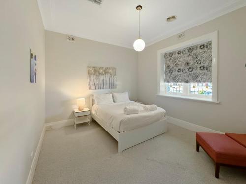 a white bedroom with a bed and a window at Classic Meets Modern in Central Wagga in Wagga Wagga