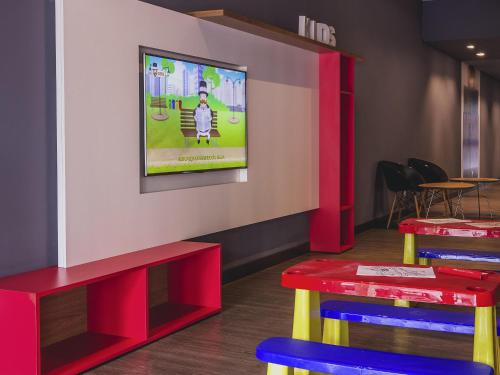 a restaurant with two tables and a tv on the wall at ibis Carlos Barbosa in Carlos Barbosa